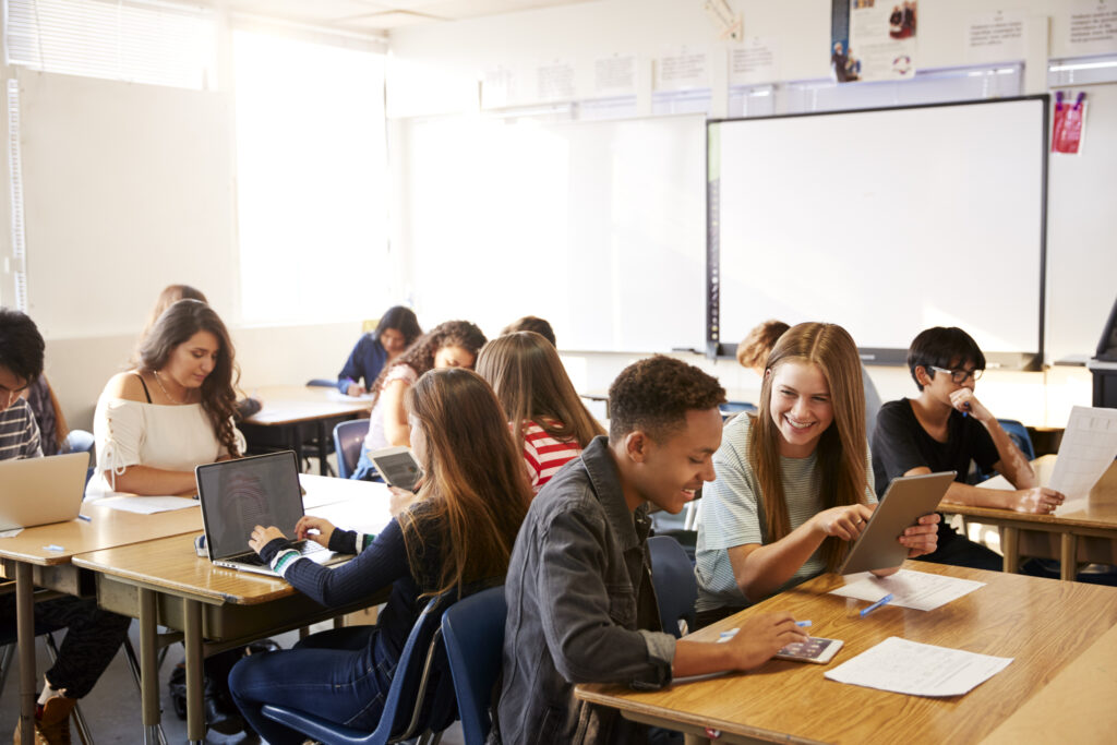 Stock image happy kids sitting in classroom at desks and tables